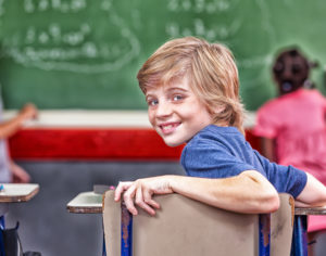 classroom strategies to include SEN child. Images shows a boy in a chair at a desk