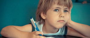 Insightful Autism Diary.. Image shows boy staring in to distance with a pen in his hand