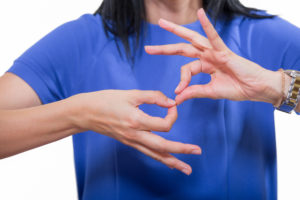 Accessibility is Important - Accessibility means giving people access to the world. Image shows person doing sign language